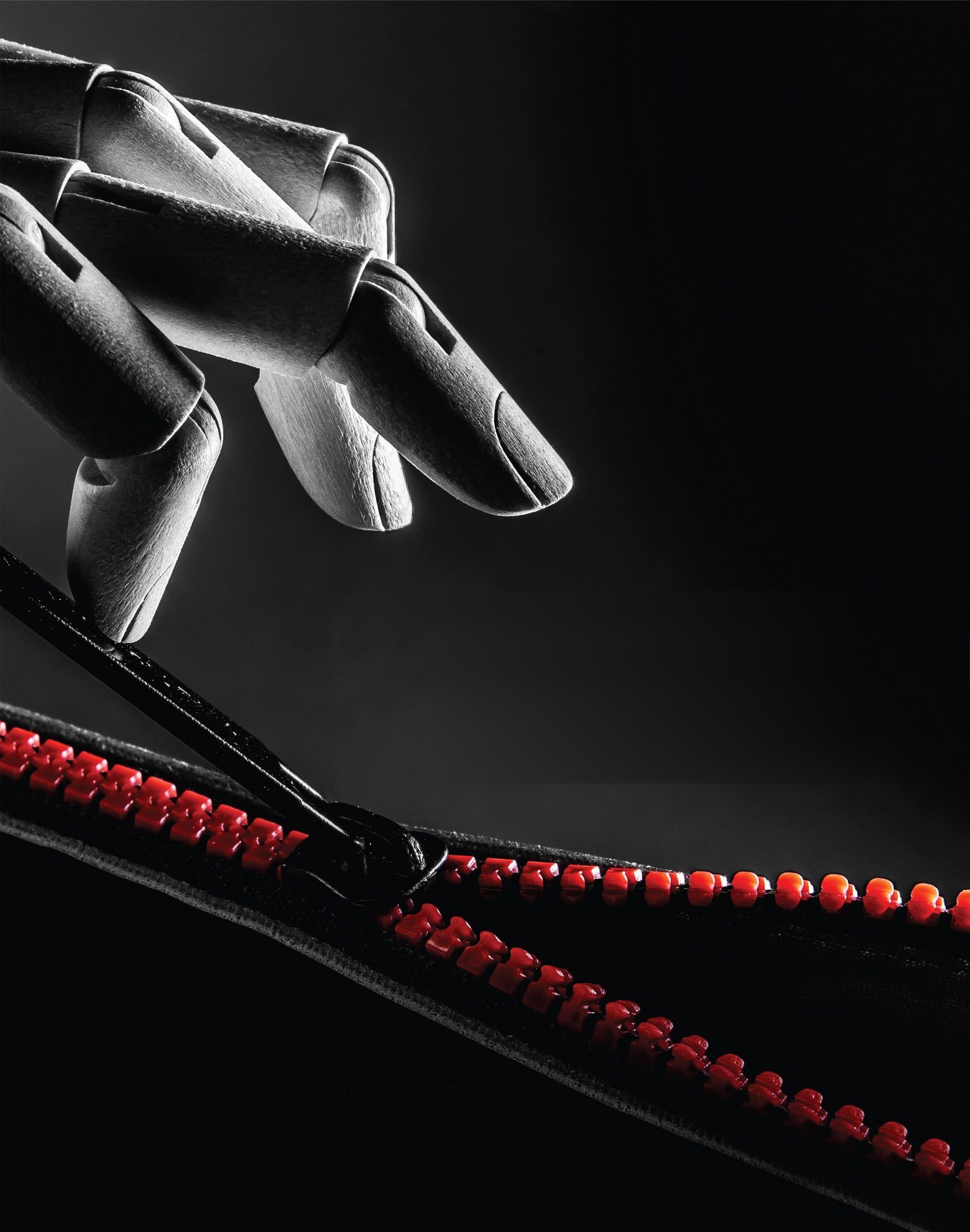 A robotic hand pulling a slider along a red and black zipper